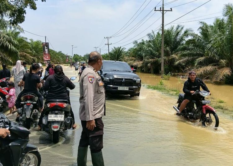 Banjir Rendam Jalan Sumor bor-Tanjung Selamat, Polsek Padang Tualang Sigap Atur Lalu Lintas